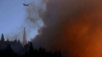 SEMAKIN MARAK: Sebuah helikopter mencurahkan air ke atas kebakaran hutan ‘Camp Fire’ di bukit dekat Cresta, California kelmarin. — Gambar AFP
