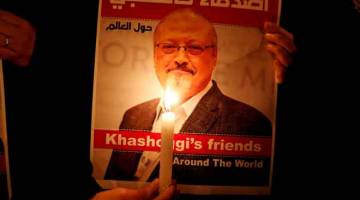 TURUT BERSIMPATI: Seorang penunjuk perasaan membawa poster dengan gambar Khashoggi                di luar konsulat Arab Saudi di Istanbul, Turki pada 25 Oktober lepas. — Gambar Reuters