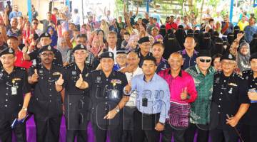 OMAR merakamkan gambar kenangan bersama penduduk Kampung Tanjung Aru sambil menunjukkan tanda bagus semasa Program Kepolisan pada Sabtu.