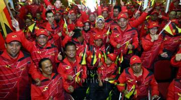 atimah (tengah) bersama para atlet Sarawak bagi Sukan Para Sukma Ke-19, selepas upacara penyerahan bendera negeri di Kompleks Belia dan Sukan di sini, hari ini.