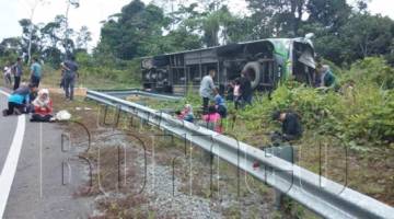 KEADAAN bas persiaran yang terbalik di bahagian kiri jalan di sini petang Jumaat lalu.