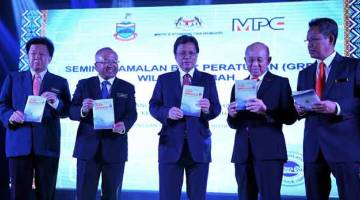 PERASMIAN: Shafie (tengah) menunjukkan buku garis panduan permohonan lesen berniaga selepas perasmian seminar Amalan Baik Peraturan (GRP) Wilayah Sabah semalam. — Gambar Bernama