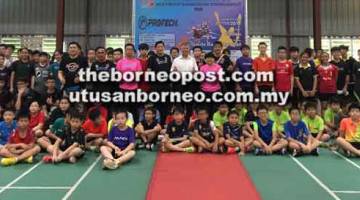 RASMI: Ting (tengah) dan Lau (kiri) dengan jawatankuasa penganjur dan peserta pertandingan badminton Kumpulan Umur Kelab Badminton Lopeng semalam.