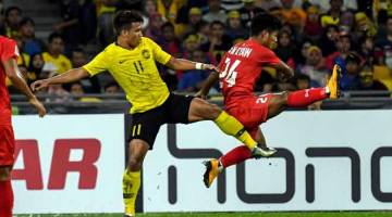 BELUM ADA REZEKI: Safawi mengasak untuk mendapatkan bola dari pemain Myanmar, Win Moe Kyaw pada aksi Kejohanan Piala AFF Suzuki 2018 di Stadium Nasional Bukit Jalil, Kuala Lumpur malam kelmarin. — Gambar Bernama