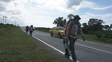 MENINGKATKAN KESEDARAN: Mahendran, Muhammad Azlan dan Norzairi melakukan ‘Walk For Cancer Malaysia’ sebagai meningkatkan kesedaran masyarakat bagi pemeriksaan kanser di Bintulu. — Gambar Bernama