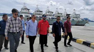 LAWAT: Mukhriz melawat sebuah daripada enam kapal penangkapan tuna milik syarikat Luhaifeng Holdings (M) Sdn Bhd (LHF) sewaktu berlabuh di Pelabuhan Tanjung Lembung. — Gambar Bernama