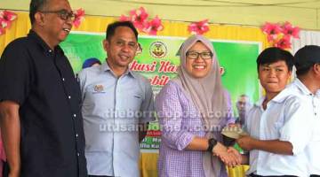 INSENTIF: Munirah menyampaikan hadiah insentif kepada pelajar UPSR 2018, sambil disaksikan Rosmin (dua kiri) dan Norawi (kiri).