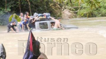 SAAT mencemaskan mengharungi arus Sungai Magandai ditarik dengan tali.