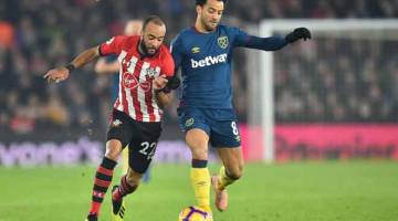 SAMA KENTAL: Anderson (kanan) berdepan tentangan sengit daripada permain Southampton, Redmond ketika bersaing pada perlawanan liga di Stadium St Mary, Southampton kelmarin. — Gambar Reuters