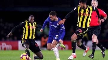 NAMPAK MUDAH: Hazard (tengah) melakukan pergerakan licik melepasi kawalan dua pemain Watford, Abdoulaye Doucoure dan Etienne Capoue (kanan) ketika beraksi pada perlawanan liga di Vicarage Road, Watford Rabu lepas. — Gambar Reuters  