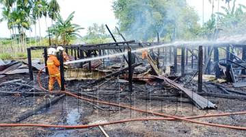 ANGGOTA bomba melakukan pemadaman api di rumah terbakar di Kampung Siasai Dandau di sini.