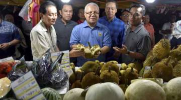 LUASKAN EKONOMI: Ishak (tengah) menunjukkan buah terap atau tarap sejenis buah yang jarang ditemui di Semenanjung ketika melawat Gerai Buah-Buahan Segar (GBBS), kelmarin. — Gambar Bernama