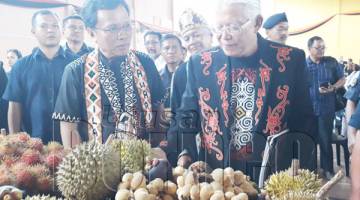 SHAFIE (kiri) bersama Richard (kanan) melawat pameran produk buah-buahan tempatan selepas merasmikan Sambutan Ilau Panawari.