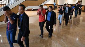 DITAHAN: Sebahagian daripada 13 kontraktor termasuk tiga wanita diiringi pegawai SPRM tiba di Mahkamah Kota Kinabalu untuk mendapatkan perintah tahanan reman semalam. — Gambar Bernama