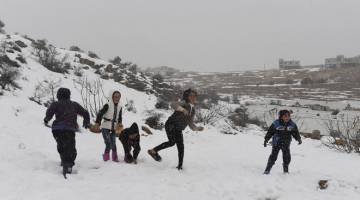 GIRANG: Anak-anak pelarian Syria bermain bebola salji sebagai rutin harian mereka ketika musim salji. — Gambar Bernama