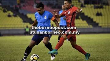 KAWAL: Kapten Melaka United, Muhammad Shukor Adan (kiri) cuba mengawal bola daripada dirampas pemain Sarawak, Abdul Rahim pada aksi persahabatan di Stadium Hang Jebat malam kelmarin. — Gambar Bernama