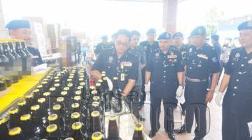 YUSOFF (dua dari kiri) memerhatikan Pesuruhjaya Polis Sabah Datuk Omar Mammah meneliti rampasan minuman keras di Pejabat PPM Wilayah 4 Sabah.