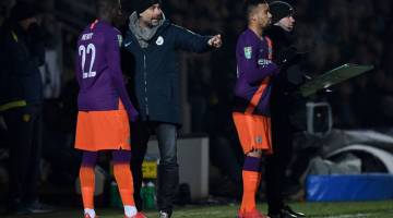 TETAP FOKUS: Guardiola memberikan arahan kepada pemainnya ketika perlawanan di Stadium Pirelli, Burton-upon-Trent Rabu lepas. — Gambar AFP