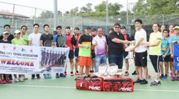 CHO (kanan) menyampaikan sumbangan untuk SSTA kepada Alex. Turut bersama ialah mentor dari Bank Daegu dan sebahagian peserta yang menyertai Klinik Tenis Ringan di KSKK.
