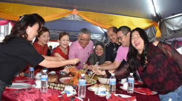 RUMAH TERBUKA: Ting (lima kanan) bersama Helen Lim (tiga kiri) serta yang lain menggaul Yee Sang semasa Rumah Terbuka Tahun Baharu Cina Lembaga Pelabuhan Rajang di sini, petang kelmarin.  