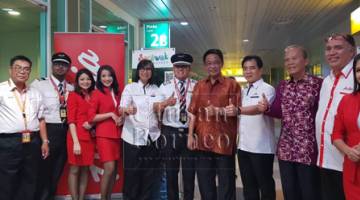 Abdul Karim (lima kanan) serta yang lain merakam kenangan ketika meraikan penerbangan AirAsia dari Lapangan Terbang Antarabangsa Kota Kinabalu di Sibu, malam tadi.