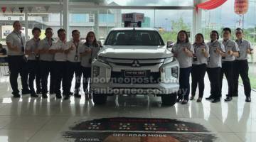 TERBAIK: Pengarah Urusan Jimisar Group, Mariana Datuk Ismail (lima kanan) dan Pengurus Jualan Jimisar Autotrade Sdn Bhd, Alice Foo (enam kiri) bersama para perunding jualan menunjukkan tanda bagus semasa memperkenalkan Mitsubishi Triton 2019 di Kuching, semalam.