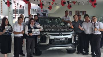 DAPATKANNYA: Pengurus Jualan Jimisar Autotrade Sdn Bhd Sibu John Lau (empat kanan, baju hitam) bersama wakil jualan pada majlis pelancaran Triton baharu di premis pameran Persiaran Brooke di sini, semalam.