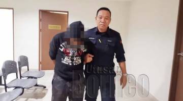 MOHD Zulkhairul (kiri) diiringi anggota polis keluar dari kamar mahkamah