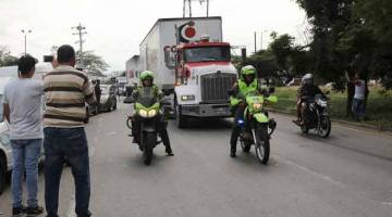 BANTUAN KEMANUSIAAN: Anggota polis mengiringi trak ketika mereka tiba di sebuah gudang, di mana bantuan kemanusiaan                    antarabangsa untuk Venezuela akan disimpan menurut pihak berkuasa, dekat jambatan merentasi sempadan Tienditas antara Colombia dan Venezuela, di Cucuta, Colombia, pada Khamis. — Gambar Reuters