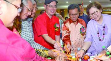 SHAFIE (dua dari kanan) bersama tetamu kehormat yang lain menggaul Yee Sang selepas merasmikan majlis itu.