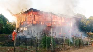 KEADAAN rumah mangsa di Kampung Bambangan di sini semasa terbakar petang Khamis.