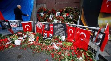 DALAM KENANGAN: Gambar fail 17 Januari, 2017 menunjukkan jambangan bunga dan gambar mangsa disusun dekat pintu masuk kelab malam Reina di Istanbul. — Gambar Reuters