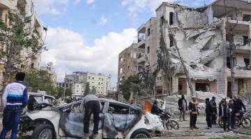 DAHSYAT: Orang ramai melihat keadaan di tempat kejadian susulan letupan bom kereta dan motosikal di Idlib, kelmarin. — Gambar AFP