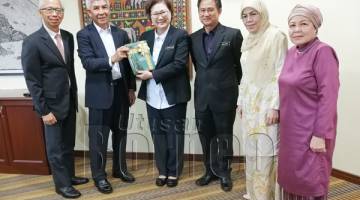 CHRISTINA (tiga kiri) menerima buku Yayasan Sabah daripada Jamalul, turut kelihatan Wiliam (tiga kanan).