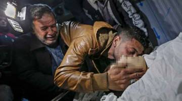 SUASANA PILU: Saudara-mara meratapi Yussef al-Daya di rumah mayat hospital al-Shifa di Kota Gaza, kelmarin. — Gambar AFP