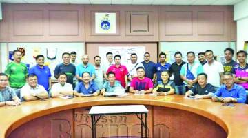 JAWATANKUASA penganjur bersama wakil-wakil pasukan semasa cabutan undi Piala FA kejohanan Bola Sepak KDM Malaysia di Kota Kinabalu Sabtu lalu.