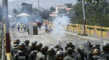 HURU-HARA: Penunjuk perasaan bertempur dengan anggota Pengawal Kebangsaan Venezuela di jambatan antarabangsa Simon Bolivar yang menghubungkan Cucuta dengan bandar Venezuela, San Antonio del Tachira – di Cucuta, Colombia pada Ahad. — Gambar AFP