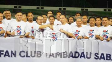 LIAWAS (kiri) menyerahkan baju Tambadau Sabah kepada Peter semasa pelancaran Fan Club Tambadau Sabah di Stadium Likas pada Selasa.