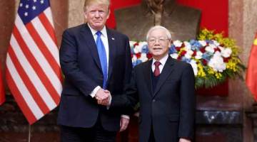 JALINAN MESRA: Trump (kiri) berjabat tangan dengan Nguyen di Istana Presiden di Hanoi, Vietnam pada Rabu menjelang sidang kemuncak kedua AS dan Korea Utara. — Gambar Reuters