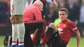 KRISIS KECEDERAAN: Herrera menerima rawatan selepas mengalami kecederaan ketika beraksi pada perlawanan liga menentang Liverpool di Old Trafford, Manchester Sabtu lepas. — Gambar AFP