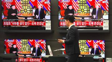 PERTEMUAN PENTING: Skrin televisyen menunjukkan siaran berita mengenai sidang kemuncak antara Kim dan Trump dalam pertemuan kedua mereka di Hanoi, Vietnam di sebuah pusat beli-belah elektronik di Seoul, Korea Selatan pada Khamis. — Gambar AFP