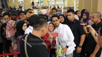 KONSERT MINI MYDIN: Sufian (tengah) berwafoto bersama peminat selepas pengakhiran konsert mini di Mydin Petra Jaya kelmarin.