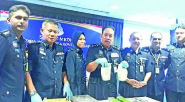 ZAINI (tengah) menunjukkan bungkusan dadah jenis syabu yang dirampas daripada suspek. Turut kelihatan Ketua Polis Daerah Sandakan Asisten Komisioner Mohd Azhar Hamin (dua kiri).