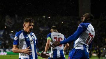 DETIK BERSEJARAH: Soares (kiri) meraikan jaringannya bersama rakan sepasukan ketika membantu Porto melangkah ke peringkat suku akhir selepas menewaskan Roma di Stadium Dragao, Porto kelmarin. — Gambar AFP