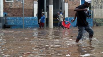 BANJIR: Penduduk menempuh jalan raya yang ditenggelami air selepas hujan lebat dalam kawasan kejiranan Vila Prudente di Sao Paulo, Brazil pada Isnin. — Gambar Reuters