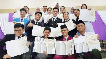 SERAMAI 17 pelajar cemerlang merakamkan gambar kenangan sambil menunjukkan sijil kecemerlangan yang diterima pada Majlis Pengumuman Keputusan SPM 2018 di SM Lok Yuk, Kota Kinabalu.
