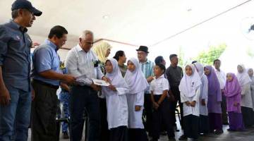 SUMBANGAN: Dr Yusof (tiga,kiri) menyampaikan sumbangan kepada murid-murid sekolah mangsa kebakaran ketika melakukan lawatan di pulau itu semalam. — Gambar bernama