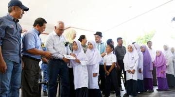 DR YUSOF Yacob (tiga,kiri) menyampaikan sumbangan kepada murid-murid sekolah mangsa kebakaran ketika melakukan lawatan di pulau itu hari ini.