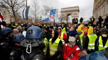 BANTAH: Penunjuk perasaan memakai ves kuning ketika menyertai demonstrasi anjuran gerakan ‘ves kuning’ di Paris, Perancis, kelmarin. — Gambar Reuters
