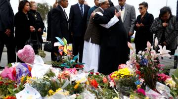 PERPADUAN UTUH: Imam Ibrahim Abdul Halim dari Masjid Linwood dipeluk oleh Father Felimoun El-Baramoussy dari Gereja Koptik semasa upacara penghormatan bagi mangsa serangan pengganas di Christchurch, New Zealand pada Isnin. — Gambar Reuters